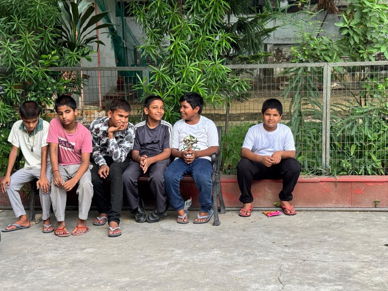 Six students from one of our partner schools for the blind sitting together outdoors