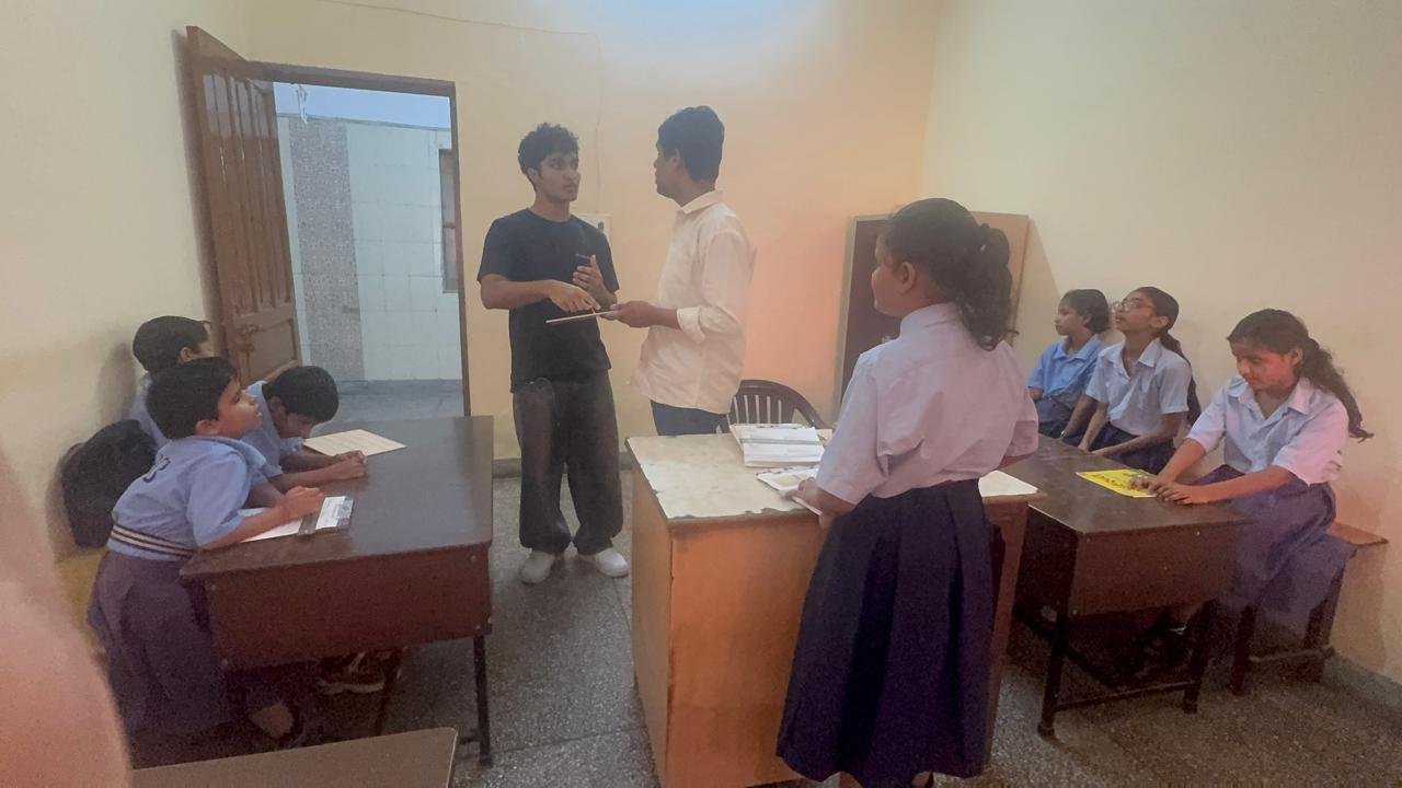 Continuing the classroom discussion with a teacher and students nearby