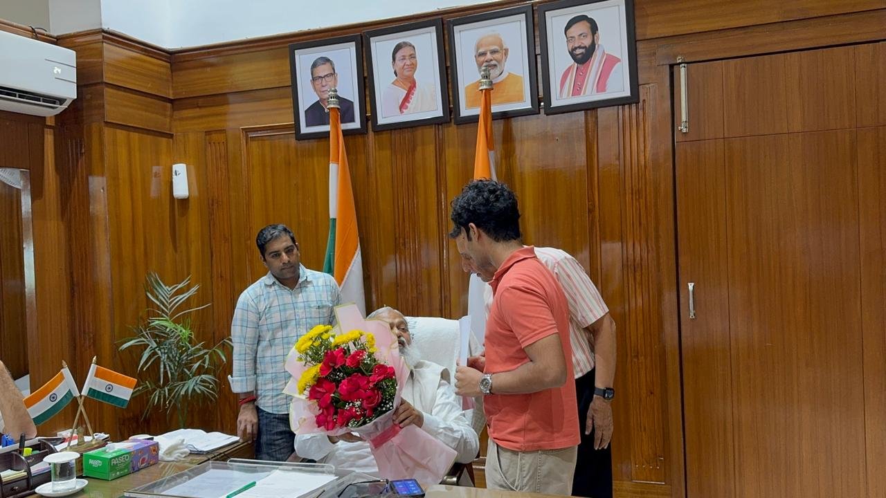 Holding the accessibility petition while speaking with Anil Vij and an official