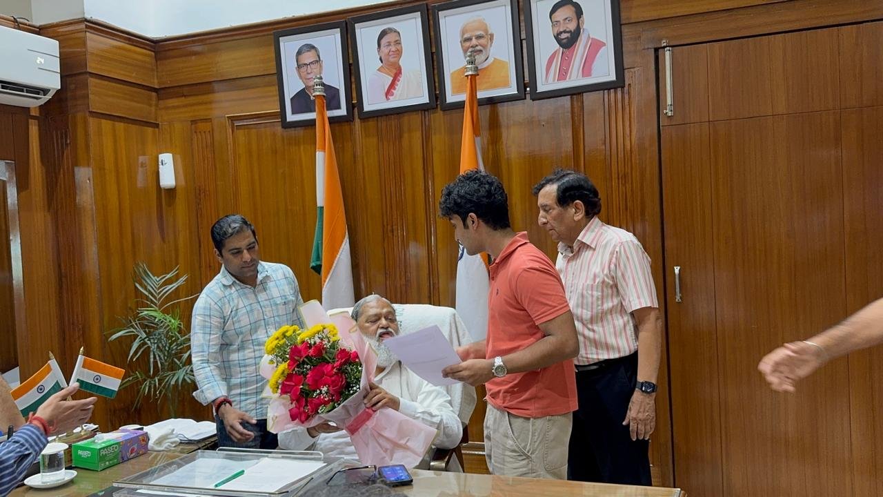 Anil Vij holding the petition up to read while listening to the policy proposals