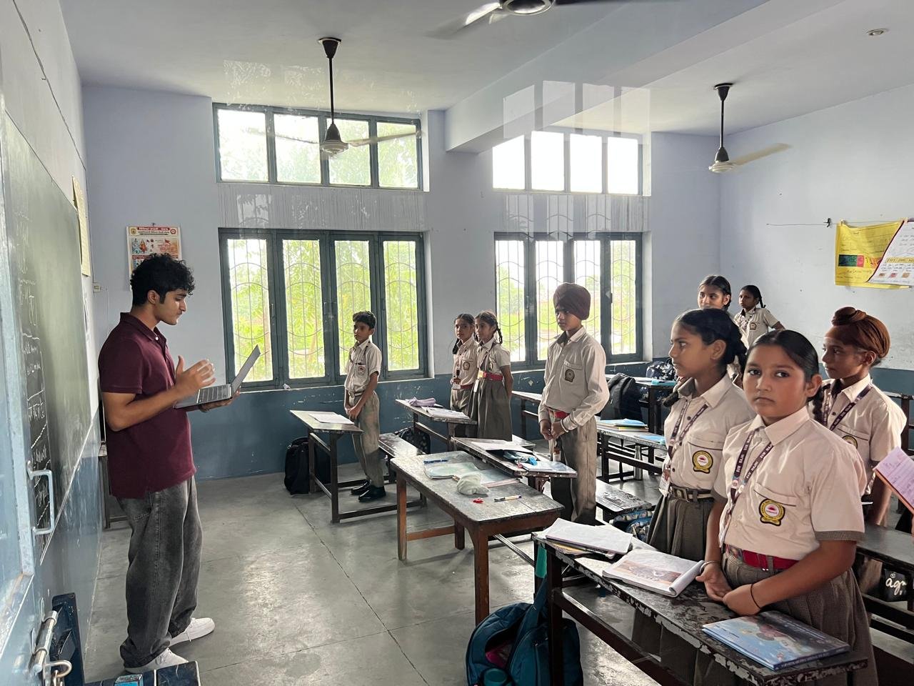 Students standing beside their desks, engaged in the workshop discussion