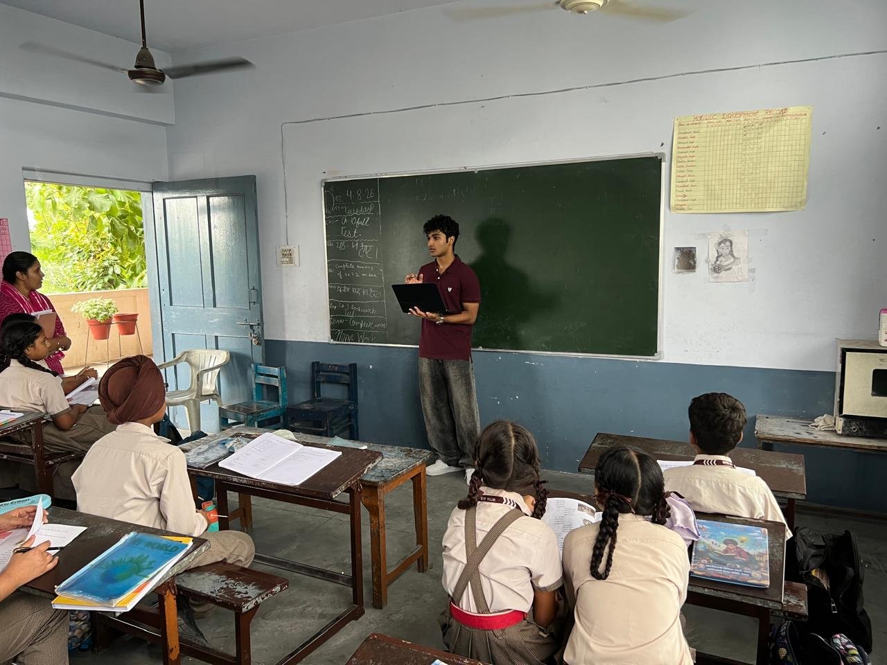 Presenting to the class as a teacher and students look on from their desks