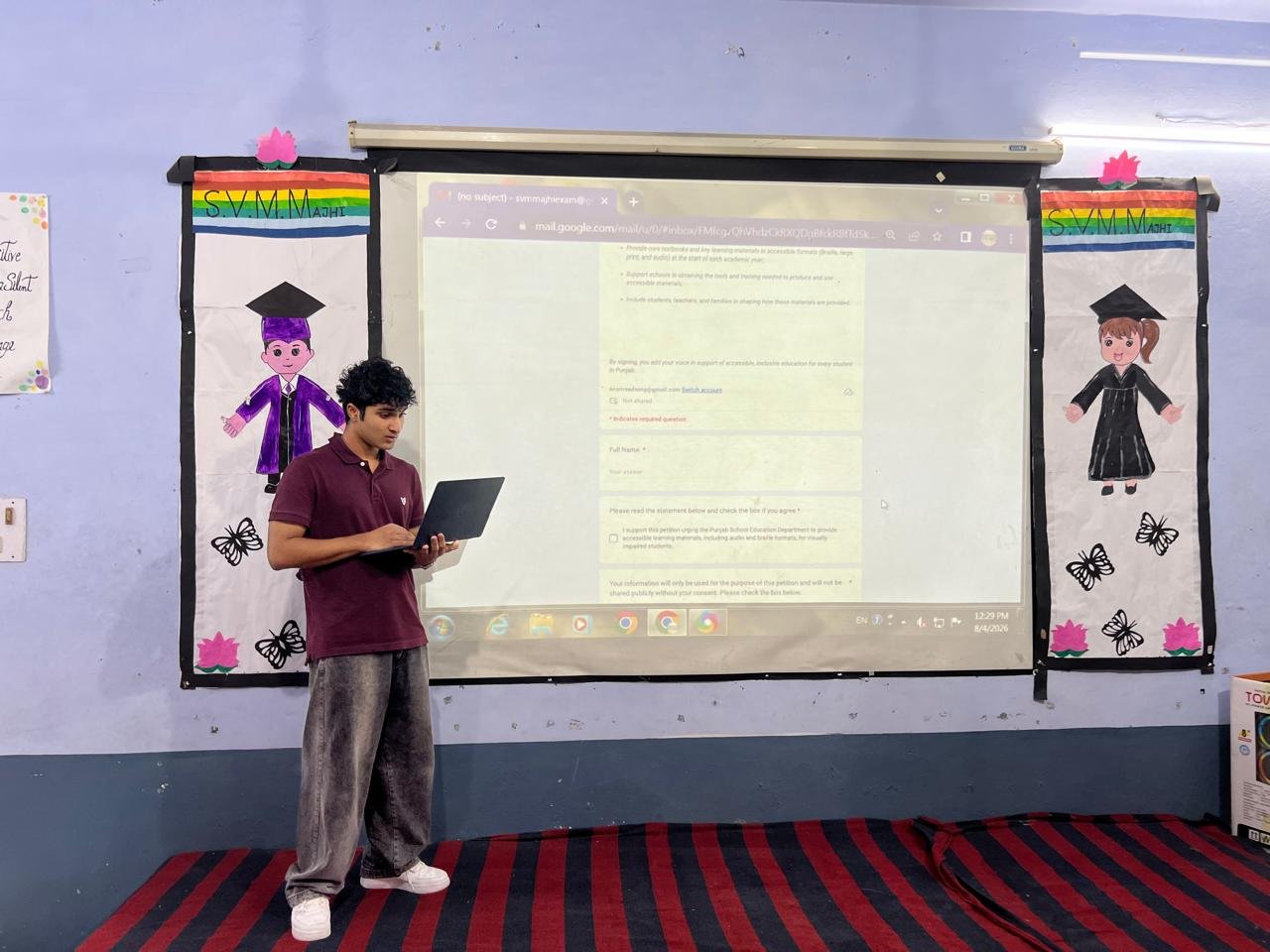 Reviewing the petition sign-up form on a laptop in front of the projected screen